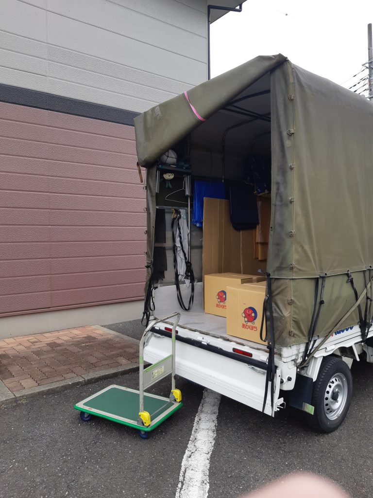 長野県松本市から神奈川県川崎市麻生区への単身引越し。川崎のアパートで荷下ろし作業中の赤帽車。台車でダンボールを運びます。